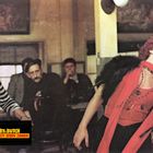 "Toby & Butch: Vier Fäuste geben Zunder". Ein Mann in Streifen und eine Frau in rotem Kleid in einer Bar.