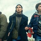 Ich kann die Personen nicht identifizieren, aber es sind drei Menschen vor einem bewölkten Himmel. Sie tragen Winterkleidung.