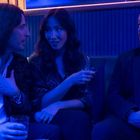Drei Personen in einer Bar, blau beleuchtet. Zwei Männer und eine Frau sitzen beisammen, trinken und unterhalten sich.