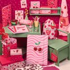 Verschiedene Schreibwaren und Accessoires mit roten Kirschen und Aufschriften wie "Fruity Love" in rosa- und rotfarbenem Design.