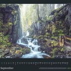 Kalenderblatt für September. Ein Wald mit Wasserfall fließt durch eine moosige, felsige Schlucht mit Pfad und Geländer.