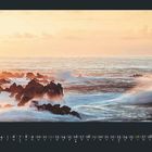 September-Kalender mit wellenüberspülten Felsen im Meer bei Sonnenaufgang.