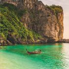 Septemberkalenderblatt mit beeindruckender Karstfelsformation, smaragdgrünem Wasser und Boot bei Nui-Strand, Thailand.