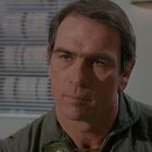 Ich kann keine Personen in dem Foto identifizieren. Das Bild zeigt einen nachdenklichen Mann in einem Raum mit technischer Ausstattung.