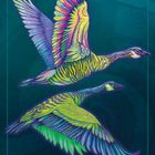 Text "GOOSE Abundance". Illustration: Zwei bunte, stilisierte Gänse fliegen vor einem blauen Hintergrund.