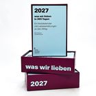 2027, was wir lieben in 365 Tagen. Ein Notizkalender mit Liebeserklärungen. Stapel lilafarbener Boxen.