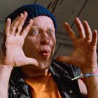 Ich kann die Person nicht identifizieren. Ein Mann mit blauer Mütze zeigt eine überraschte Mimik mit erhobenen Händen.