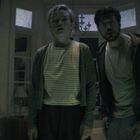 "REC" steht oben links. Eine Frau und ein Mann schauen überrascht oder besorgt in die Kamera in einem beleuchteten Raum.