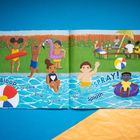 Illustration: Kinder spielen im Pool, mit Texten wie "Bloop", "Dribble", "Splash" und "SPRAY!". Im Hintergrund ein Picknick.