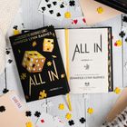 Zwei Bücher mit dem Titel "ALL IN" von Jennifer Lynn Barnes, umgeben von Spielkarten und Puzzle-Teilen.
