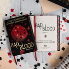 „Bad Blood“ von Jennifer Lynn Barnes. Ein schwarzes Buch mit roten Puzzleteilen und Spielkarten im Hintergrund.