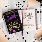 „KILLER INSTINCT“ von Jennifer Lynn Barnes, umgeben von Spielkarten und Puzzle-Teilen auf hellem Holz.