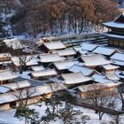 View of the Gwolnaegaksa, Changdeokgung Palace. Schneebedeckte traditionelle Gebäude inmitten von Bäumen im Winter.