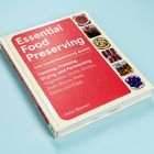 Buch mit rotem Cover, der Titel lautet "Essential Food Preserving", Bilder von konservierten Lebensmitteln sind abgebildet.
