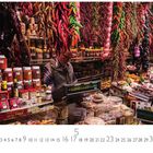 Mercat de la Boqueria. Marktstand mit Gewürzen, getrockneten Chilis und verschiedenen Lebensmitteln. Ein Verkäufer steht an der Kasse.