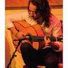 Ziffern von 1–31 in Kalenderanordnung. Ein Mann spielt Gitarre, rote Hintergrundbeleuchtung, Mikrofon vor ihm.