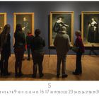 "Rijksmuseum Amsterdam" steht links unten. Mehrere Personen betrachten vier klassische Gemälde an einer blauen Wand.