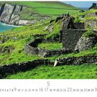 "Slea Head" steht unten links. Die Landschaft zeigt grüne Wiesen, Trockenmauern und steil abfallende Klippen an der Küste.