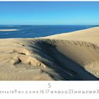 "Atlantik Düne von Pyla" steht unten. Sanddünen führen zum blauen Meer unter klarem Himmel.