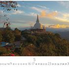 "Buddhistischer Tempel"; Kalenderdarstellung: Monat Mai, Landschaft mit Tempel auf einem Hügel, umgeben von Bäumen, Sonnenuntergang.