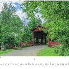 "New Hampshire Covered Bridge" steht oben links. Eine rote, überdachte Brücke umgeben von grünem Laub.