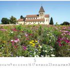 "Insel Reichenau, 5, CASARES EDITION." Eine Wiese mit bunten Blumen vor einer alten Kirche mit rotem Dach.