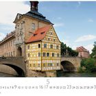 Bamberg, Altes Rathaus. Zahlen 1-31, darunter die 5 hervorgehoben. Fachwerkhaus auf Brücke über Fluss, sonniger Himmel.