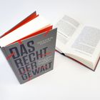 Zwei Bücher, eins geöffnet, eins geschlossen mit dem Titel "Das Recht der Gewalt" von Hendrik Simon.
