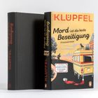 „Mord ist die beste Beseitigung“, Kriminalroman von Volker Klüpfel. Cover zeigt einen Wohnwagen mit Besen und Blutflecken.