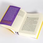 Ein Buch liegt offen, links ein lilafarbenes Textfeld und rechts eine schwarze Druckseite. Gelber Umschlag.