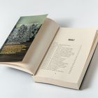 Ein Buch liegt geöffnet, sichtbar ist das Inhaltsverzeichnis und ein Text auf einem separaten Blatt.