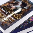 „Better in Black“, „Cassandra Clare“. Buchcover mit verschnörkeltem Rahmen und einem Paar. Darunter ein weiteres Buch.