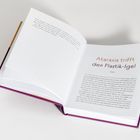 Buch aufgeschlagen: "Ataraxia trifft den Plastik-Igel". Seitenzahlen 22 und 23 sichtbar, Text darüber verteilt.