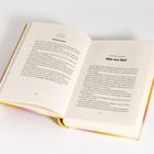 Eine offene Buchseite zeigt die Überschrift „Zweites Kapitel: Was tun Sie?“ und textliche Inhalte auf beiden Seiten.