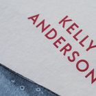 Text: KELLY ANDERSON in roten Buchstaben auf strukturiertem Papier, darunter eine blaue, illustrierte Fläche.