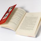 EINS. Ein Buch liegt aufgeschlagen auf hellem Hintergrund, mit einem roten Einleger. Seitenzahlen und Text sind sichtbar.