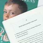 Ein Buch zeigt Kapitelüberschrift "Verfall dokumentiert man nicht" und einen Jungen auf einem grünen Buchcover im Hintergrund.