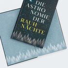 Auf einem Buchcover steht: "DIE ASTRONOMIE DER RAUH NÄCHTE". Darunter der Name "HANSER". Cover zeigt einen sternklaren Himmel.