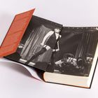 Langer Textabschnitt in Weiß auf rotem Hintergrund, daneben ein schwarz-weiß Foto von einer Bühnenaufführung mit Tänzern.