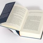 Aufgeschlagenes Buch mit sichtbaren Seiten 36 und 37, darüber ein dunkelblauer Schutzumschlag mit Textpassagen.