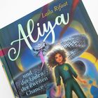 Buchcover mit „Laila Rifaat, Aliya und der Laden der Zweiten Chance“. Illustration zeigt Mädchen und Schlange mit buntem Hintergrund.