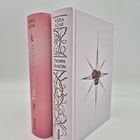 Zwei Bücher: "Kiera Azar, Thorn Season". Eines rosa, das andere weiß mit Dorn- und Rosenmotiven. Beide mit Piper-Logo.