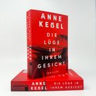 „Anne Kesel, Die Lüge in Ihrem Gesicht, Thriller“. Zwei rote Buchcover mit schwarzem Haarmotiv, eins vertikal, eins horizontal.