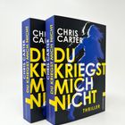 Text: "Du kriegst mich nicht", "Chris Carter", "Thriller". Zwei Bücher mit blauer Silhouette im Vordergrund.