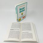 „Besser denken“ von Henning Beck. Zwei Bücher, eins aufrecht, eins offen, mit Text über Problemlösungen und Tipps.