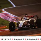 "Dezember 2027" steht links. Ein Formel-1-Auto auf einer Rennstrecke bei Sonnenuntergang. Kalenderansicht unten.