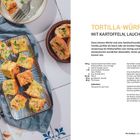 TORTILLA-WÜRFEL mit Kartoffeln, Lauch und Erbsen. Rezept mit Zutaten und Zubereitung. Links gebratene Würfel, Brot, Oliven.