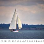 Kalenderblatt mit Monat Mai und Datumsangaben. Ein Segelboot segelt auf einem ruhigen Meer vor bewölktem Himmel.