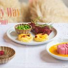 "I Did It My Way (Paris Bar Menü)" in pastellfarbenem Text. Teller mit Erbsen, Fleischstücken, Kartoffeltörtchen auf Tisch.