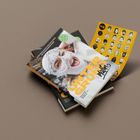 „UNTER GRUND“ auf einem Magazin mit Frau in gestrickter Maske, daneben gelber Stickerbogen mit Gesichtern.